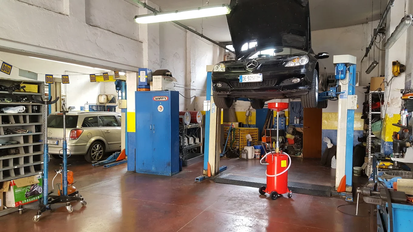 Interno dell'officina meccanica DMC con auto sul ponte sollevatore